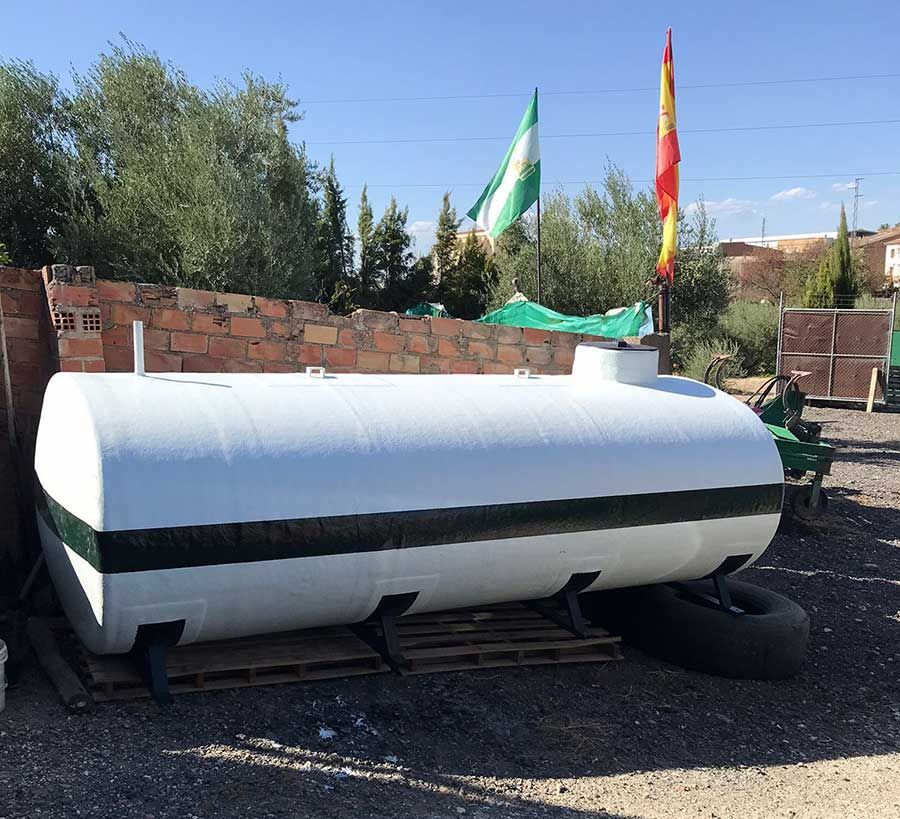 Un gran tanque blanco está situado encima de una pila de grava.