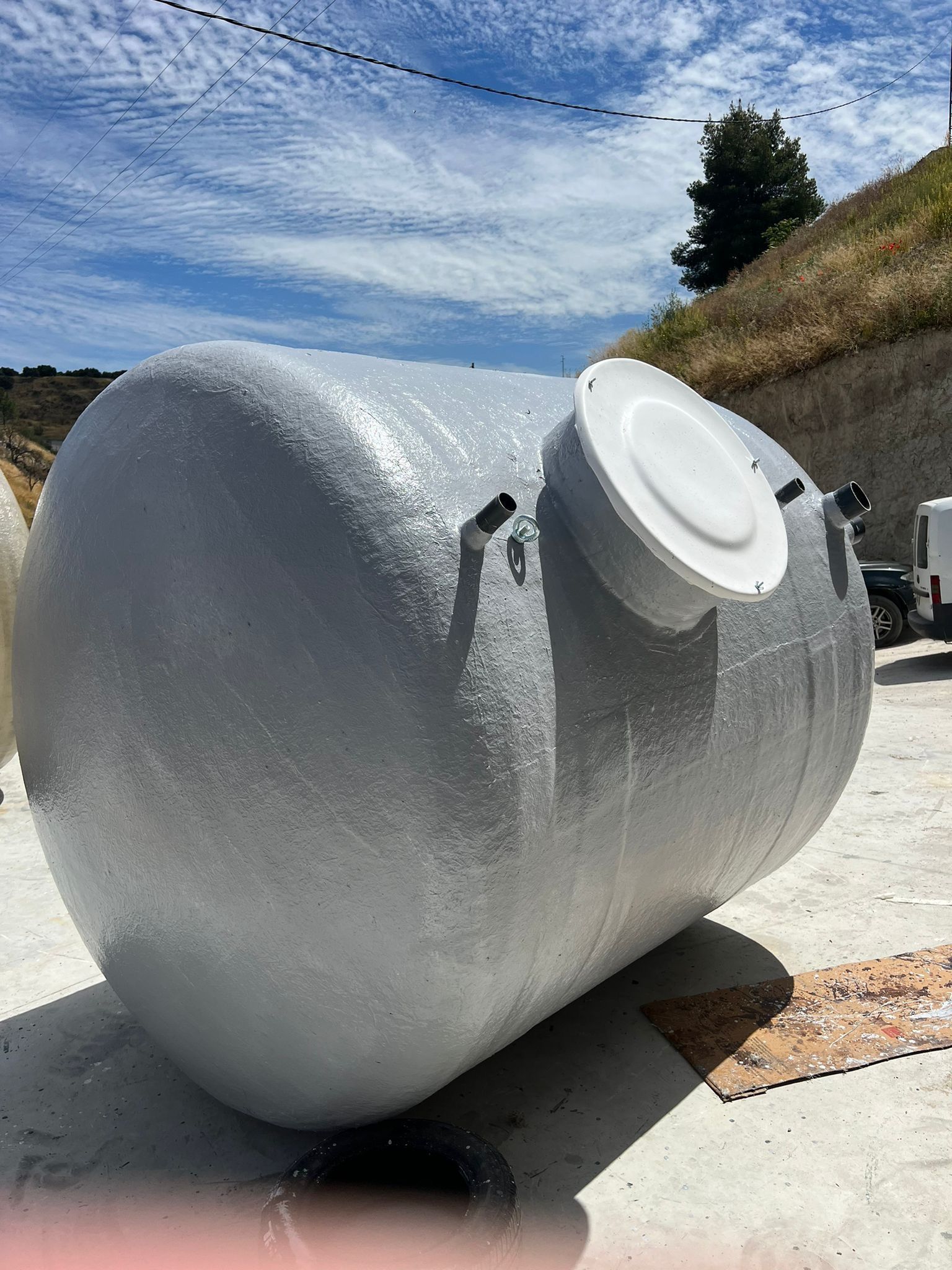 Un gran tanque blanco está situado encima de una superficie de hormigón.