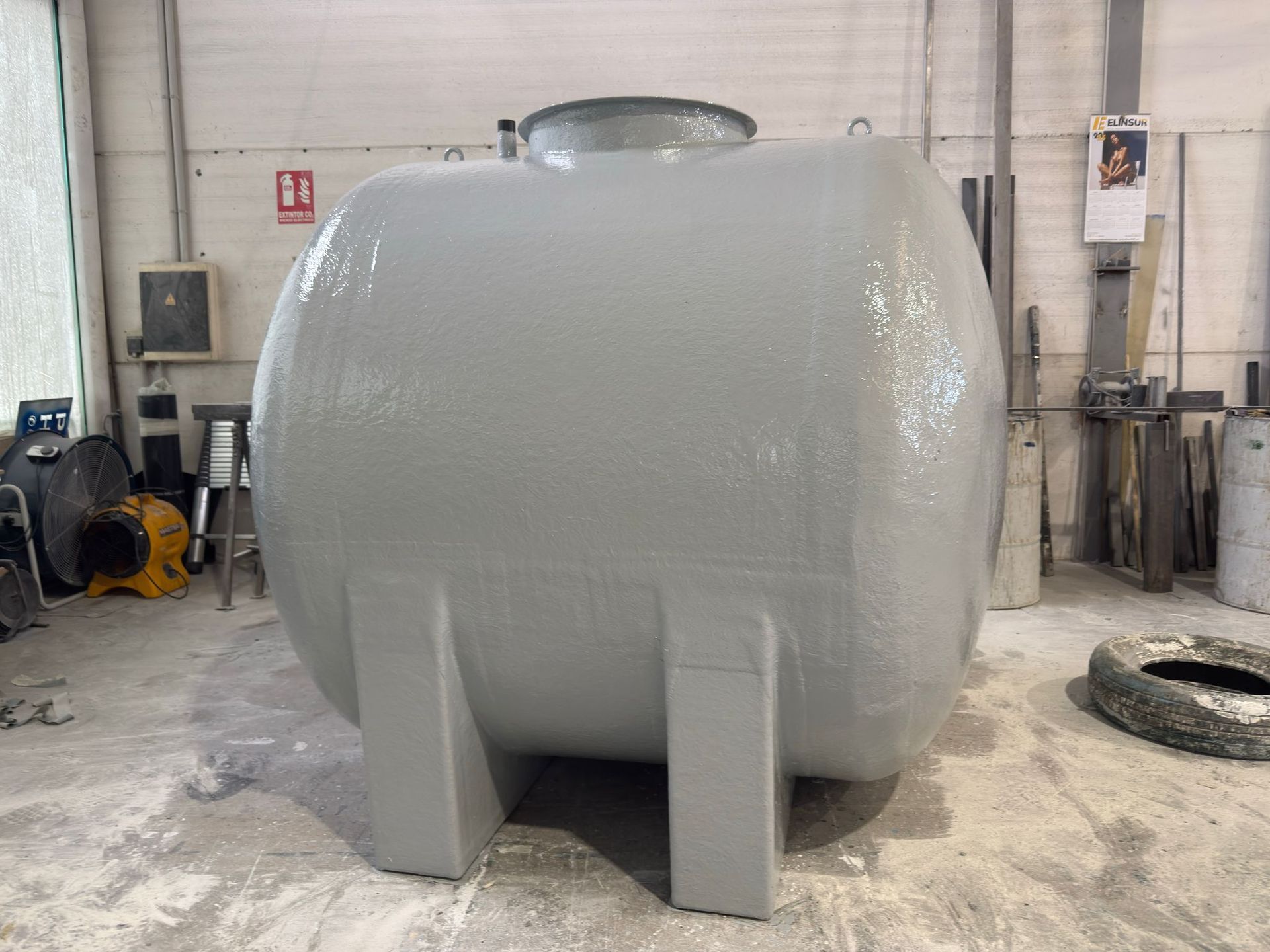 Un gran tanque gris está estacionado en un almacén.