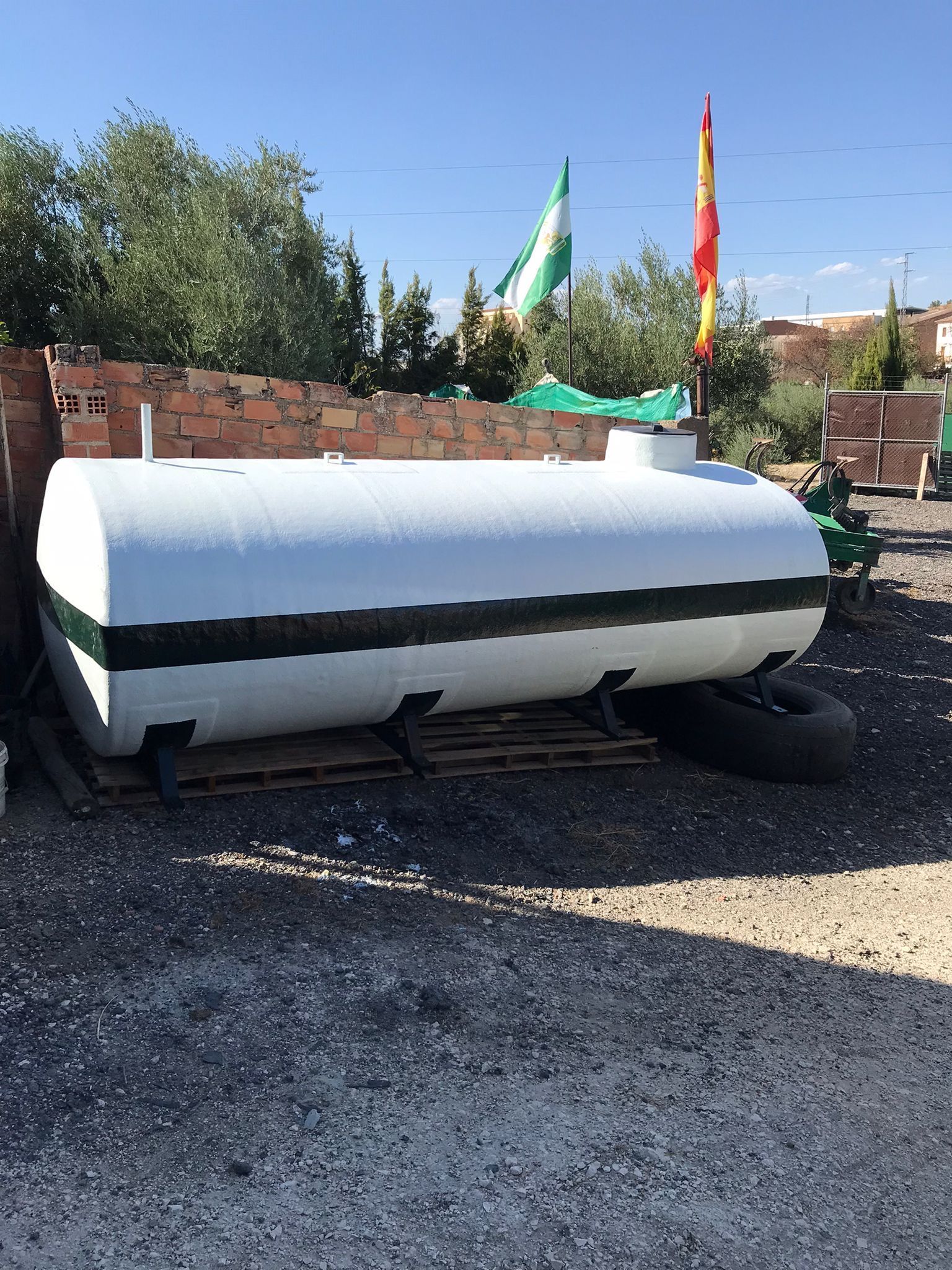 Un gran tanque blanco está situado encima de una pila de grava.