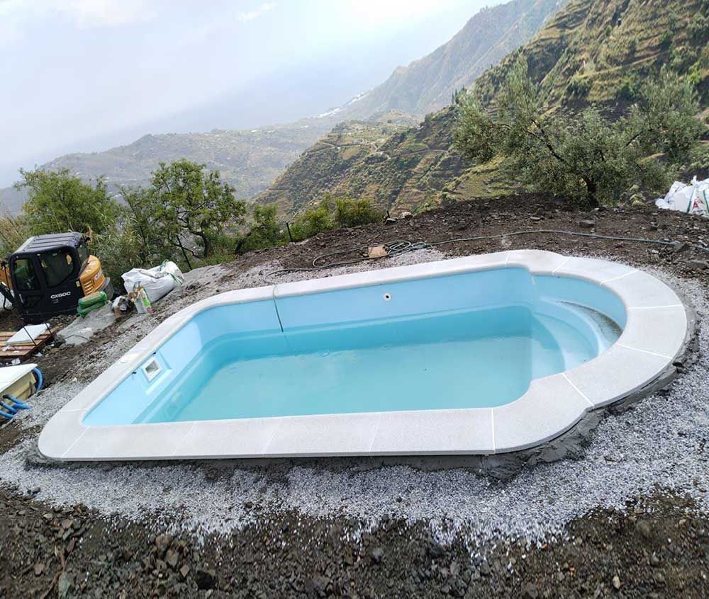 Una piscina frente a una casa con techo azul