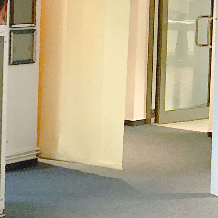 Beigefarbener Vorhang neben einer Tür mit Glaseinsätzen.