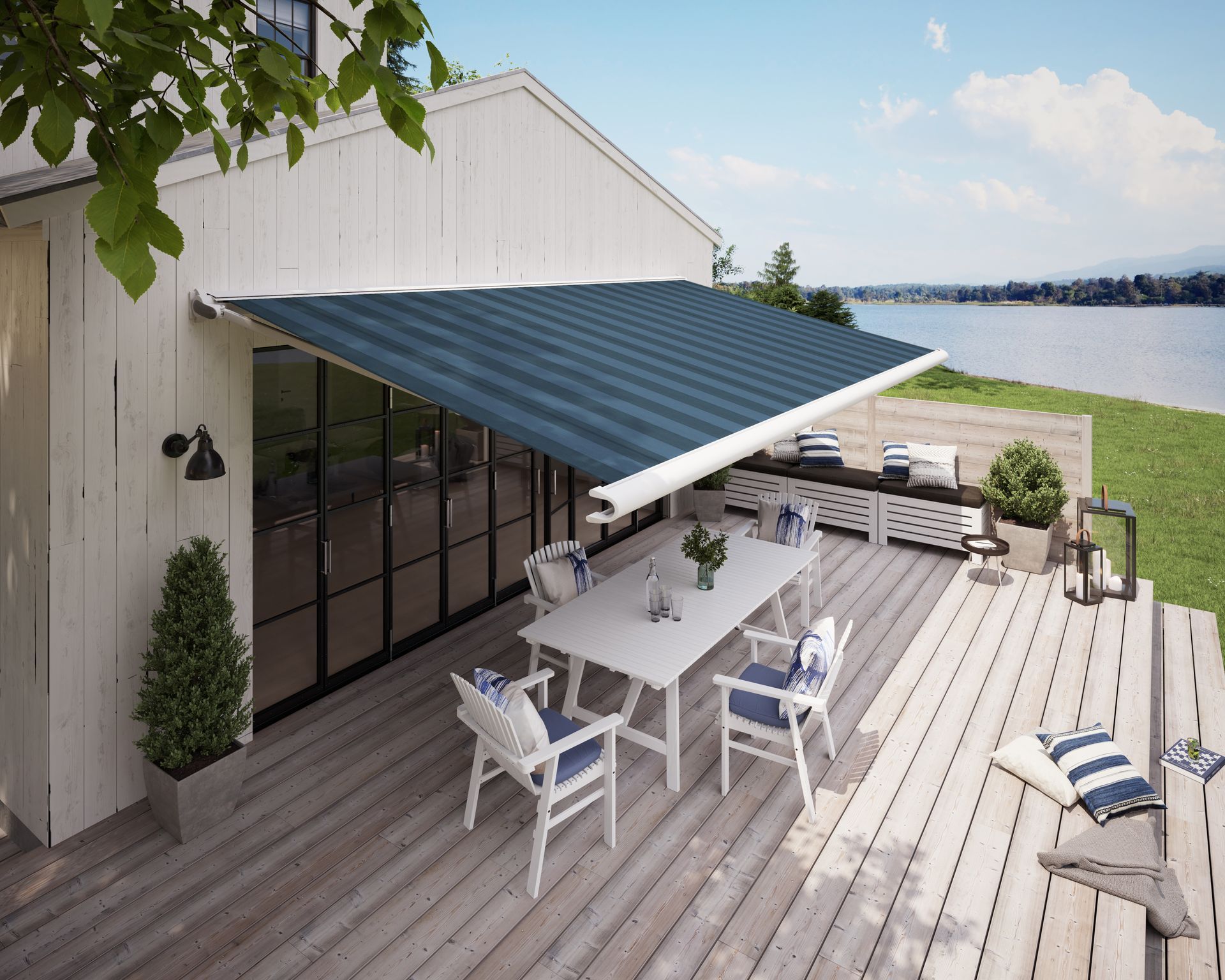 Weiße Markisen spenden Schatten über einem Gebäude mit großen Fenstern. Zwei Liegestühle stehen auf einer Terrasse.