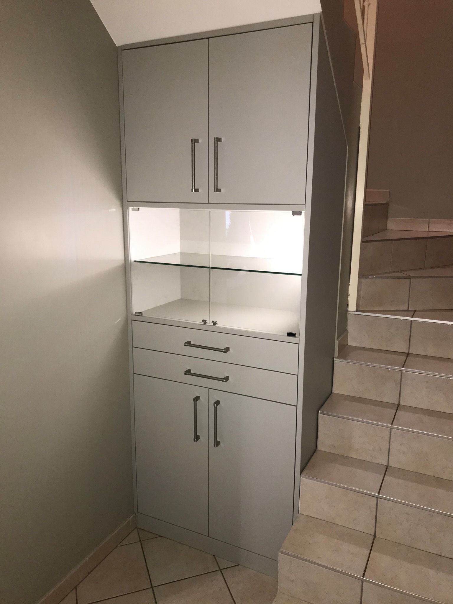 Placard blanc éclairé à côté d'un escalier