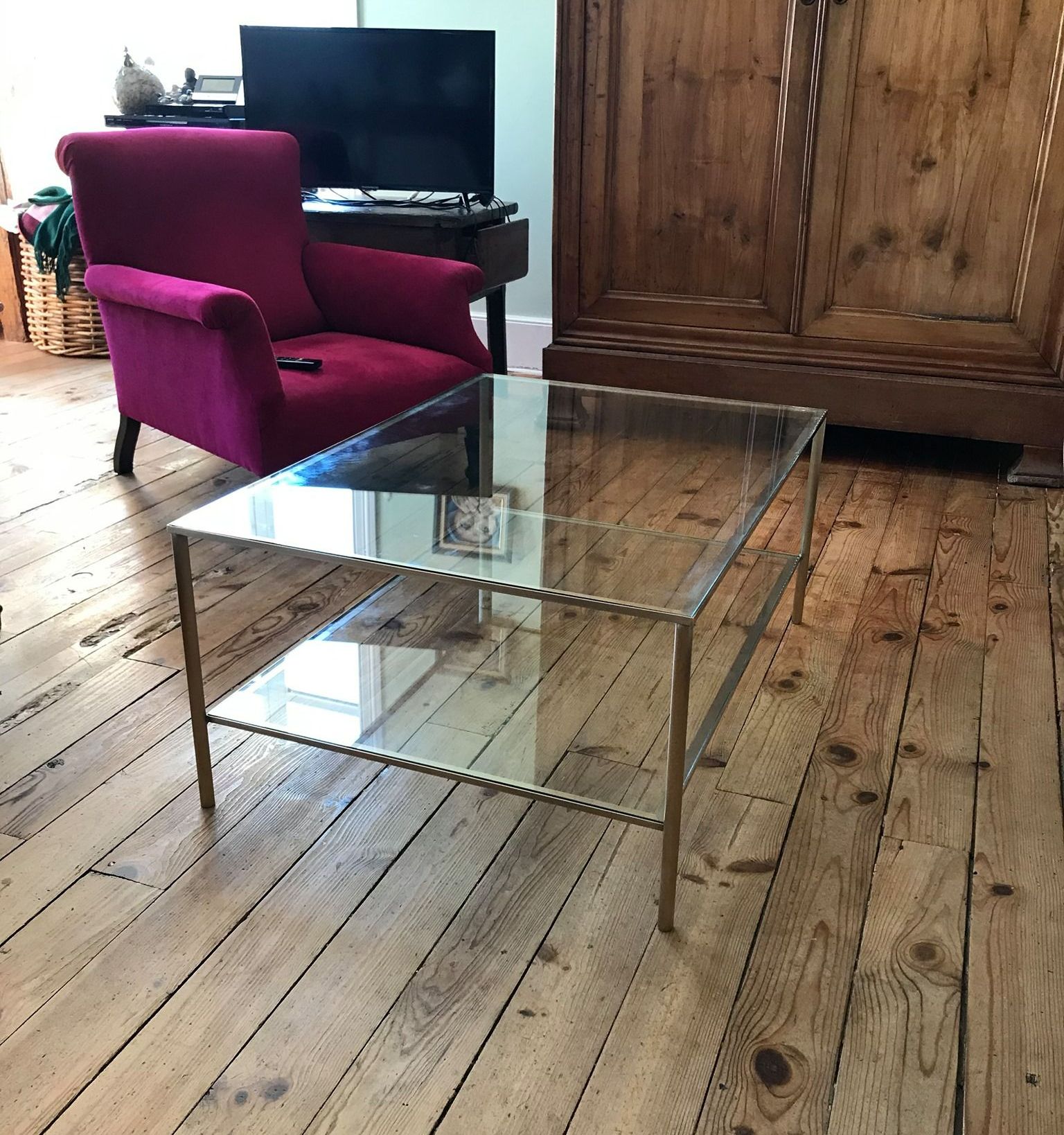 Armoire, fauteuil et table basse sur un vieux parquet