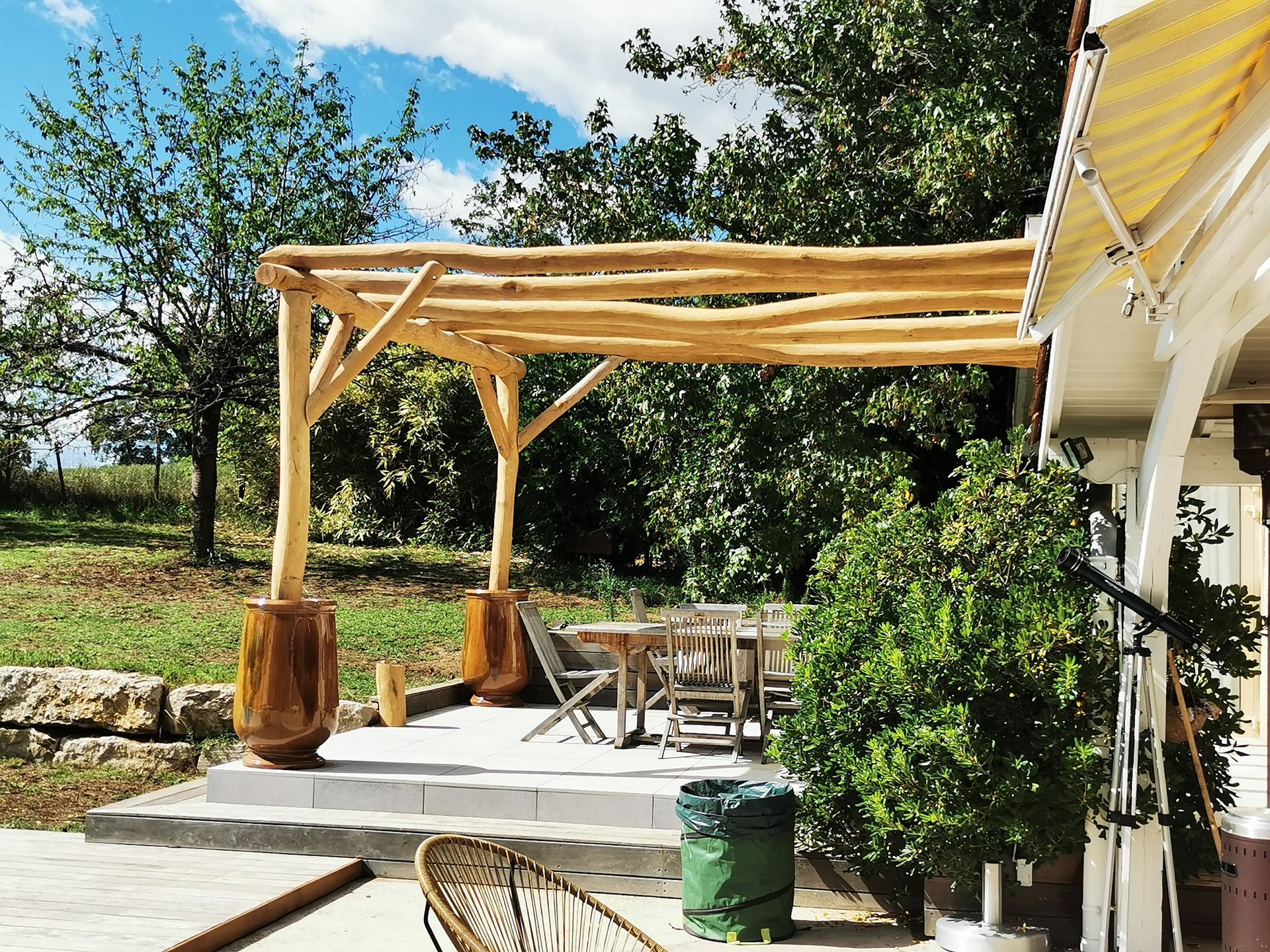 Pergola en troncs d'arbres le long d'une maison