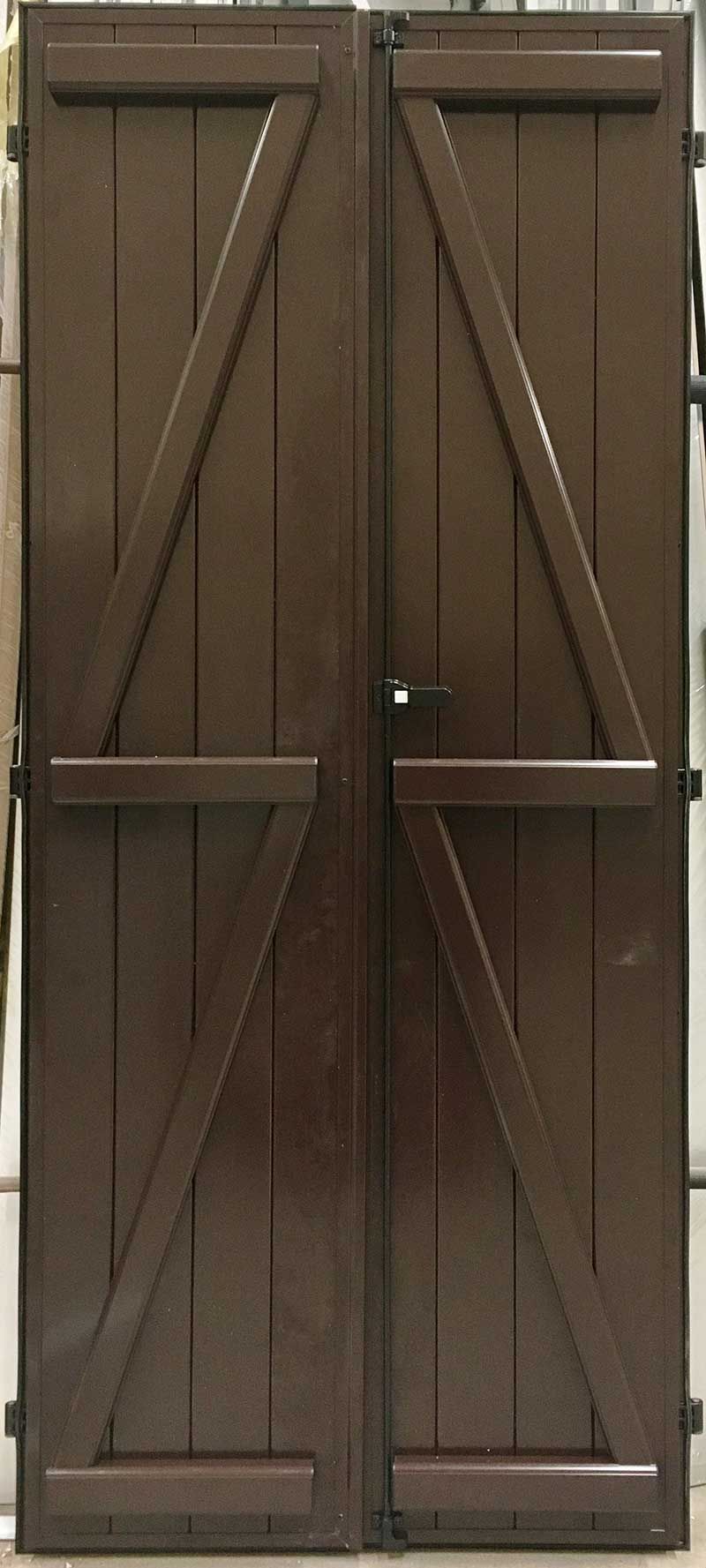 Un par de contraventanas o puertas de madera de color marrón oscuro con un diseño de refuerzo en forma de Z en cada panel.