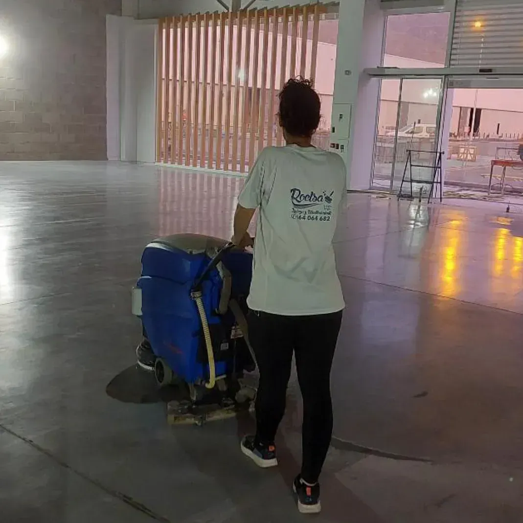 chica con camiseta blanca y pantalon negro llevando una pulidora