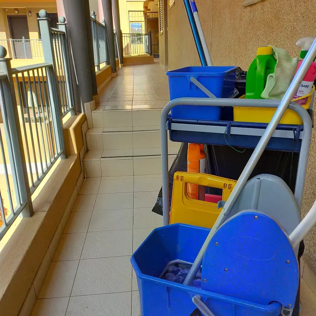 Un carrito de limpieza con un trapeador y un balde encima.