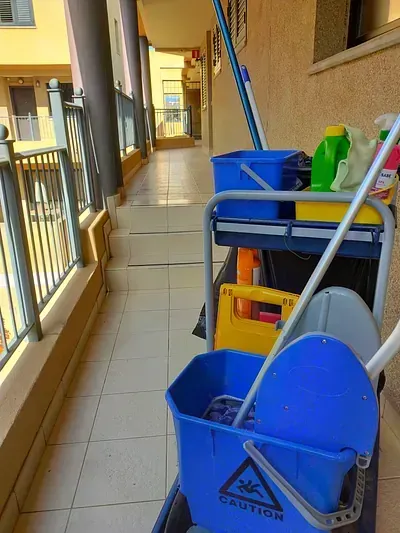 Un carrito de limpieza con un trapeador y un balde encima.