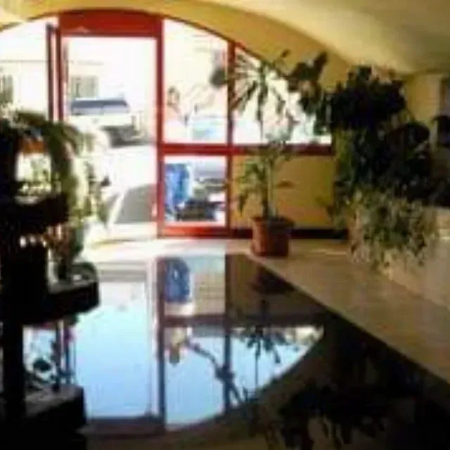 Una sala de estar con un piano, plantas y una puerta roja.