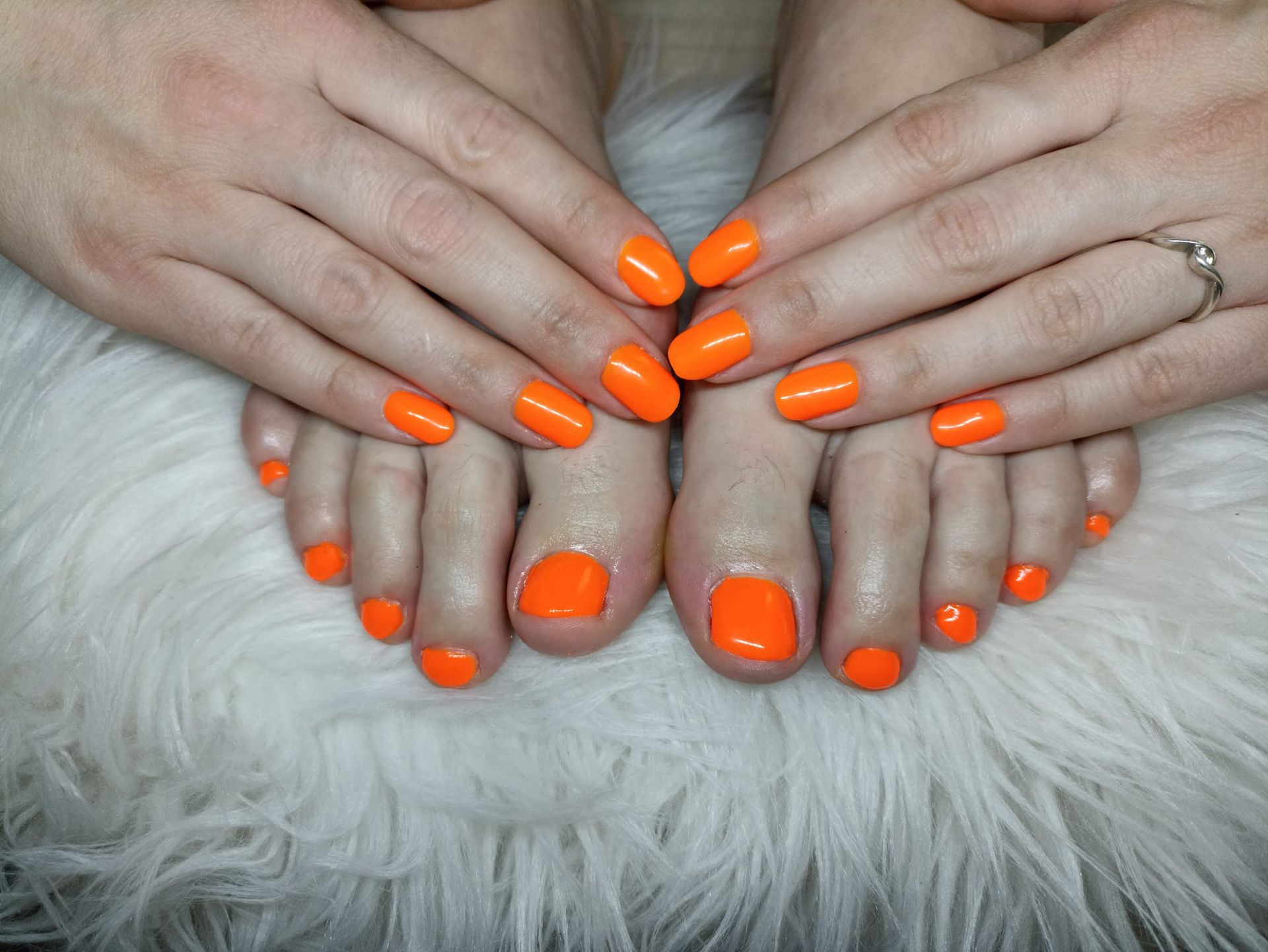 Vernis orange sur mains et pieds