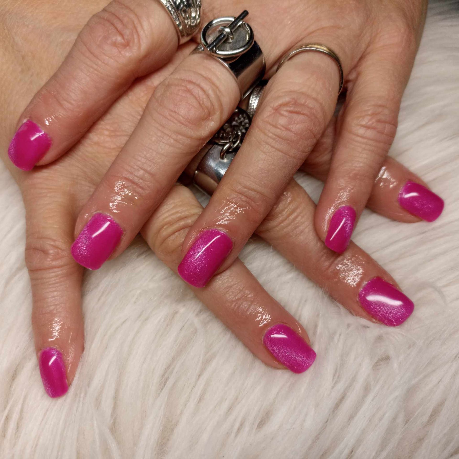 Mains avec des extensions d'ongles rose