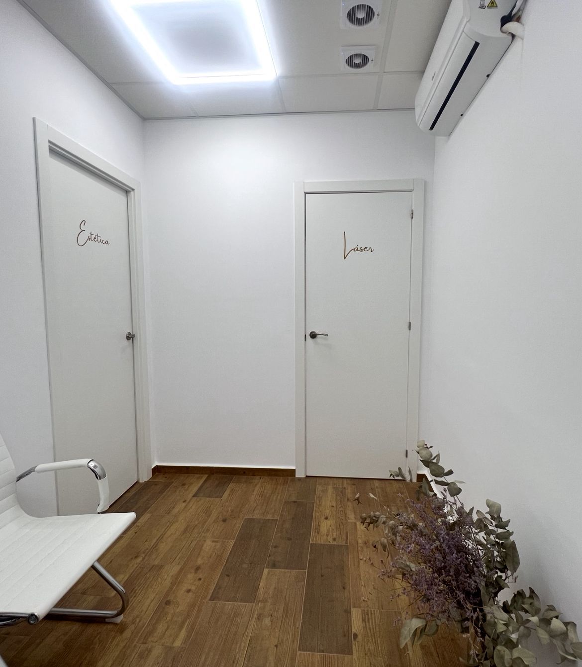 Pasillo blanco con dos puertas con letreros 