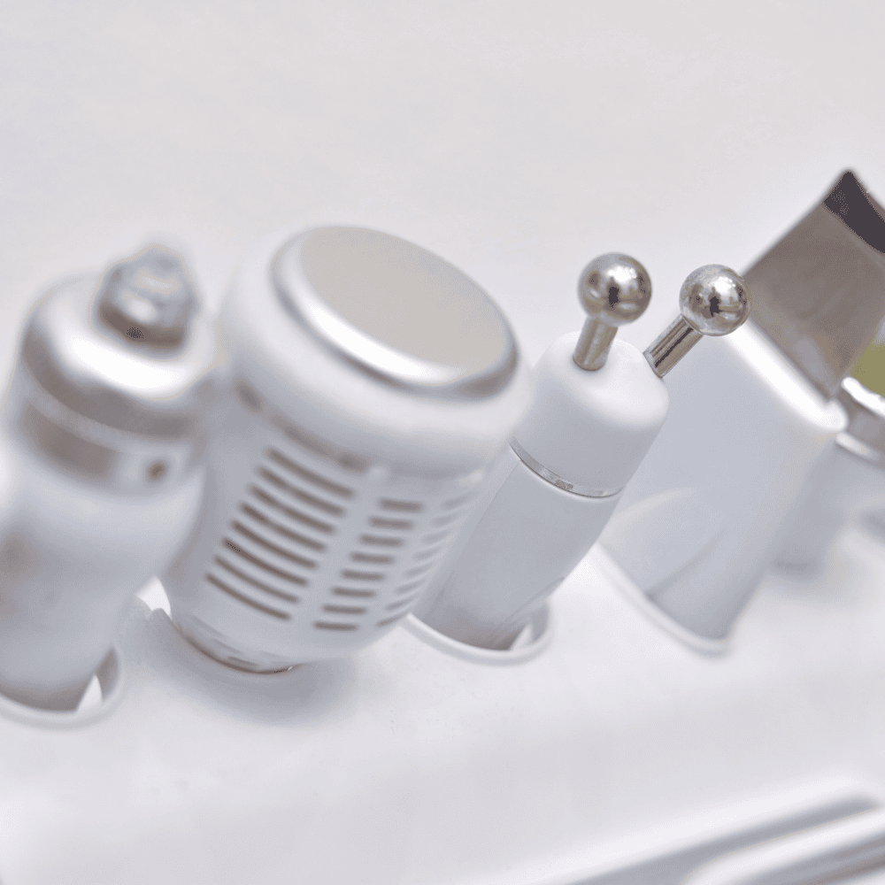 Primer plano de accesorios de máquina de estética blanca, de diferentes formas y tamaños.