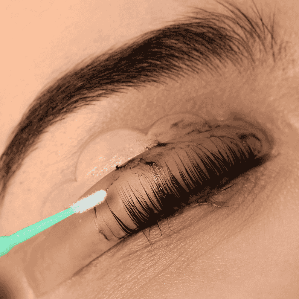 Primer plano de un ojo con pestañas tratadas con un hisopo de algodón; piel morena, pestañas y cejas oscuras.
