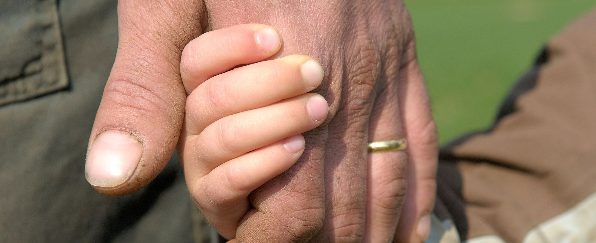 Main d'un enfant dans celle de son papa