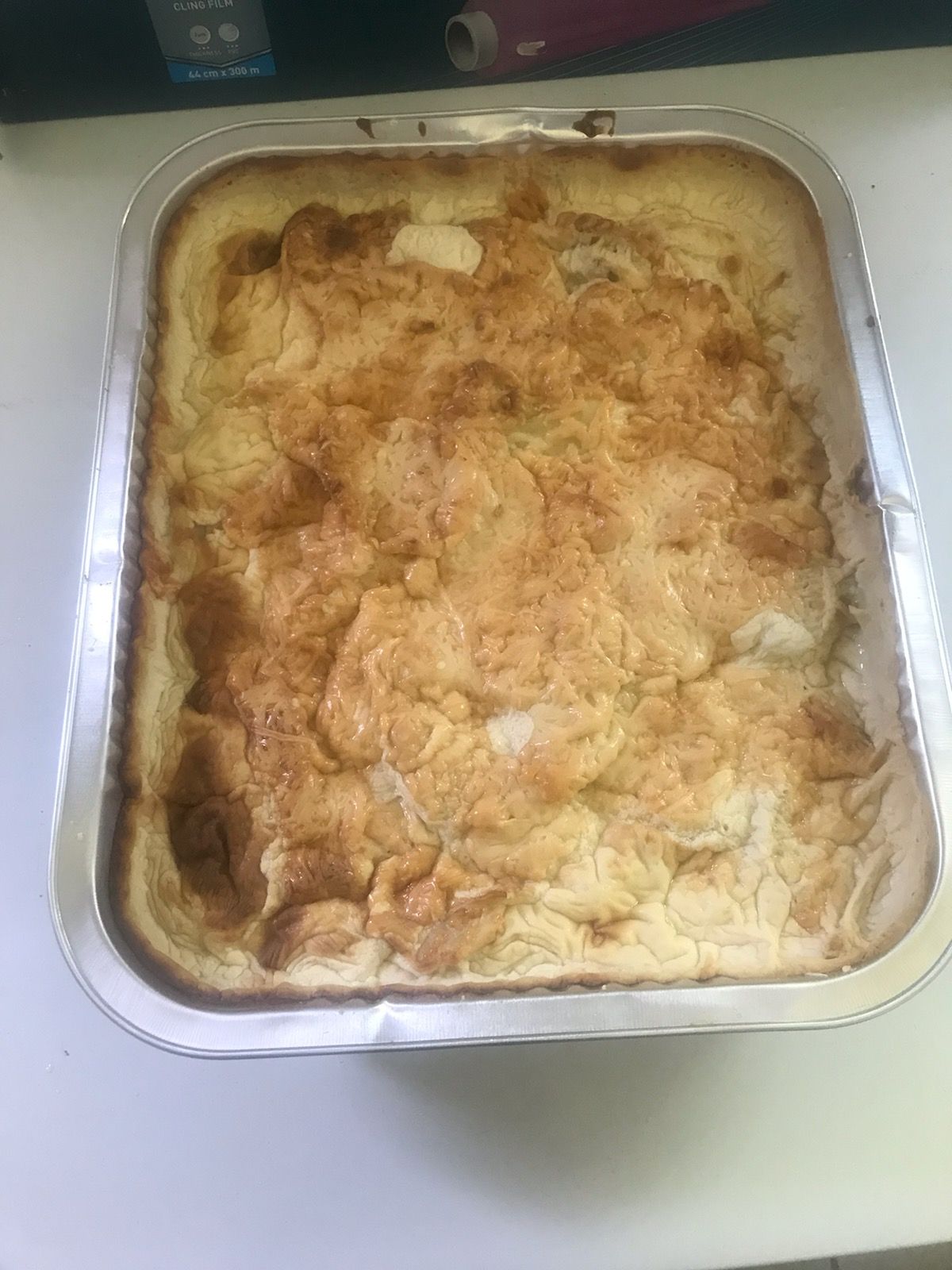 Casserole cuite au four dans un moule rectangulaire en aluminium, dessus doré.