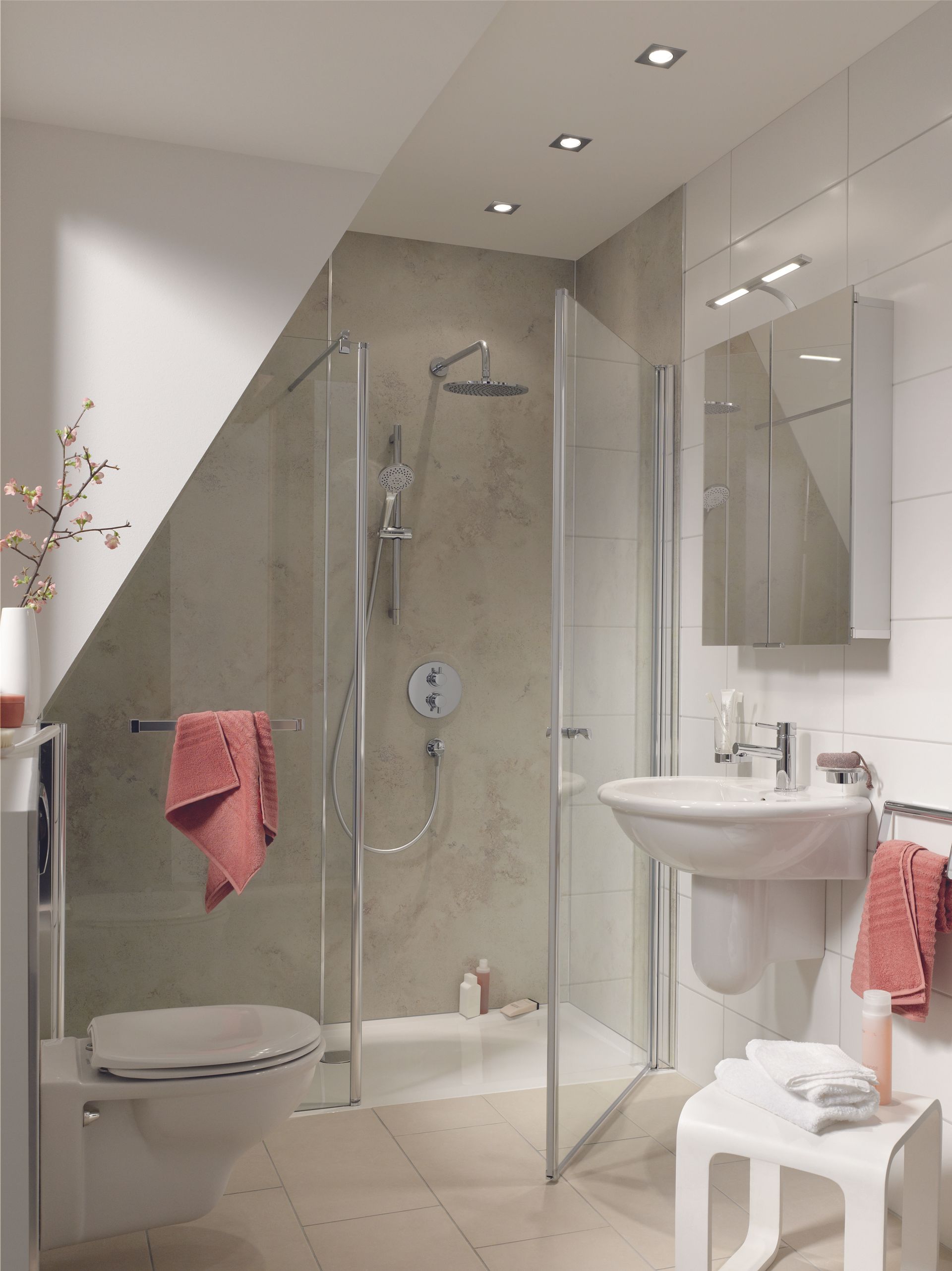 Modernes Badezimmer mit Glasdusche, WC, Waschbecken und rosa Handtüchern an weißen Wänden