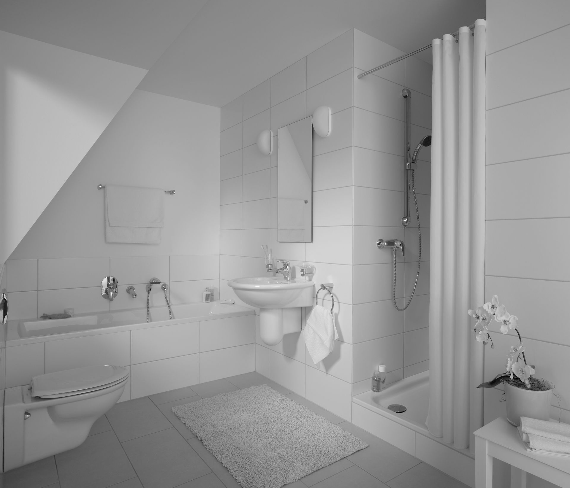 Helles, weißes Badezimmer mit Badewanne, Waschbecken, Dusche, Spiegel und kleinem Teppich am Fenster.