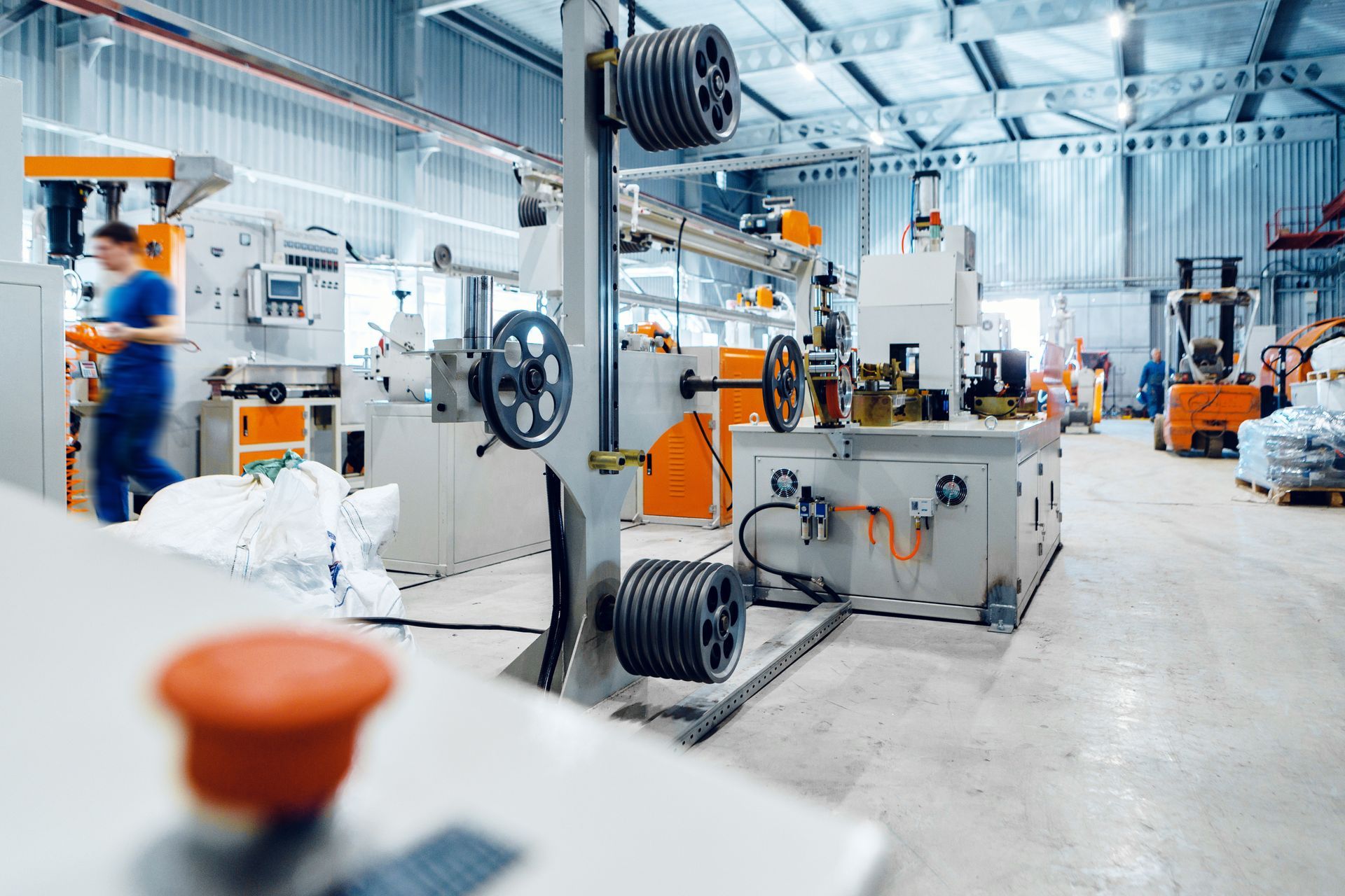 Fabrikhalle mit Maschinen und Arbeitern.