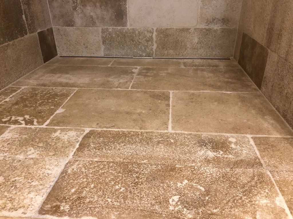 Duschinnenraum mit Steinfliesen. Beige Fliesen auf Boden und Wänden.