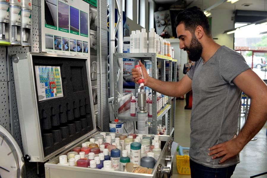 Person füllt Autolack mit rote Farbe bei der PR-Autoteile in Lüdenscheid