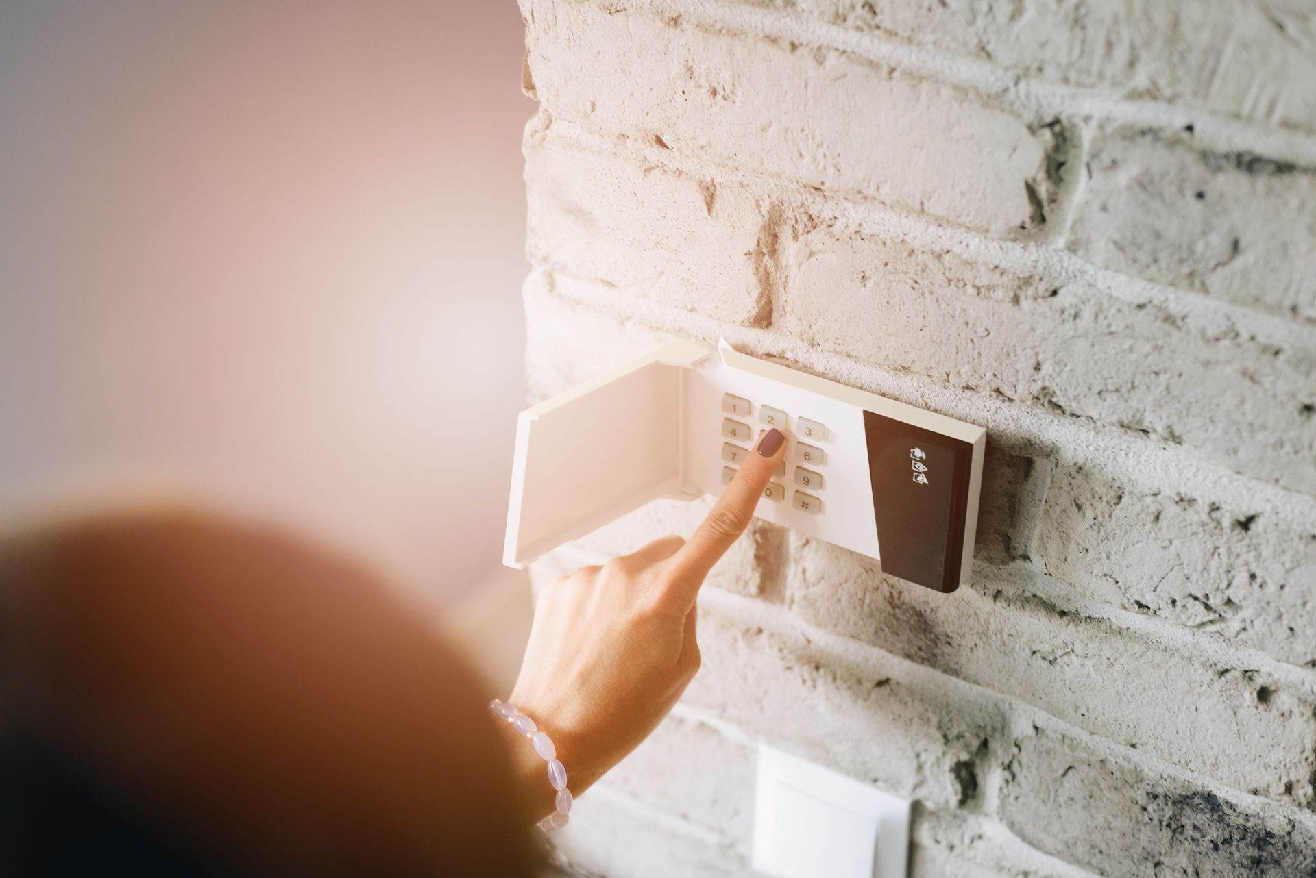 Un dedo introduce un código en un teclado táctil montado en la pared de una vivienda.