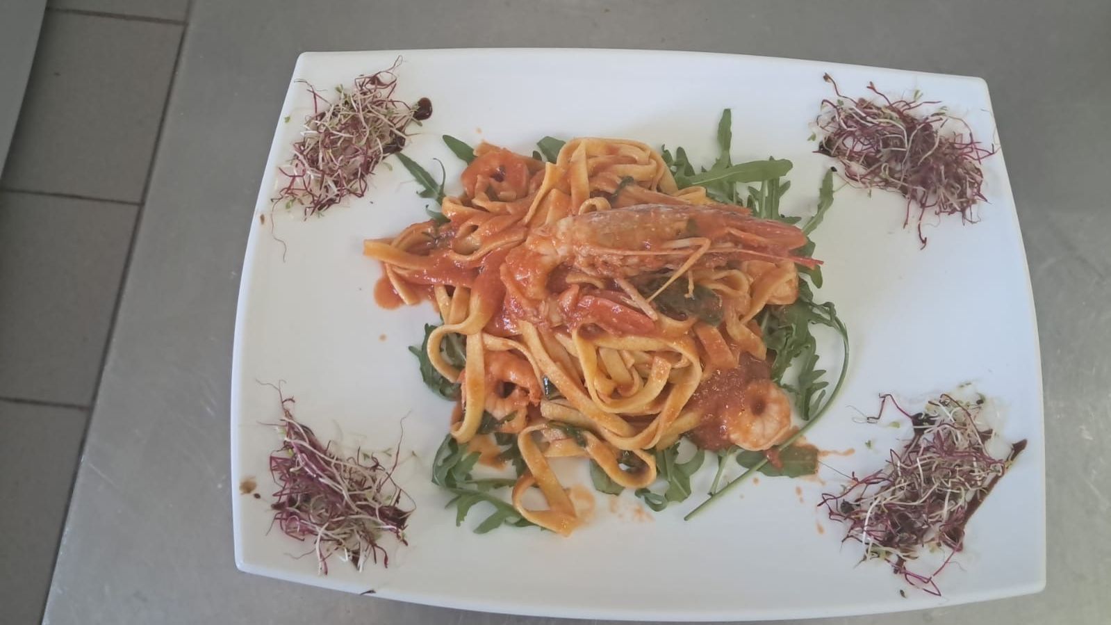 Ein weißer Teller mit Nudeln und Garnelen auf einem Tisch