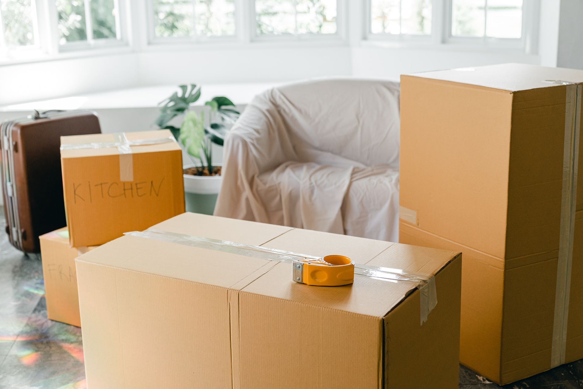 Una sala de estar llena de cajas de cartón y un sofá.