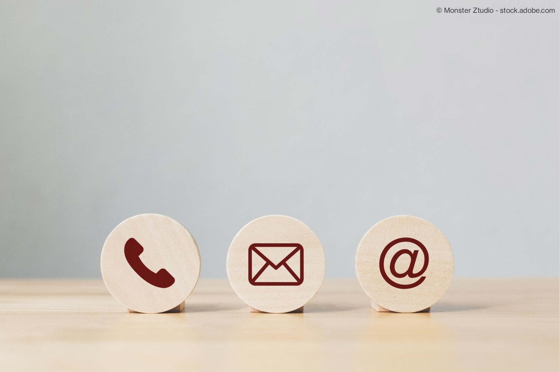 Drei Kontakt-Icons auf Holz