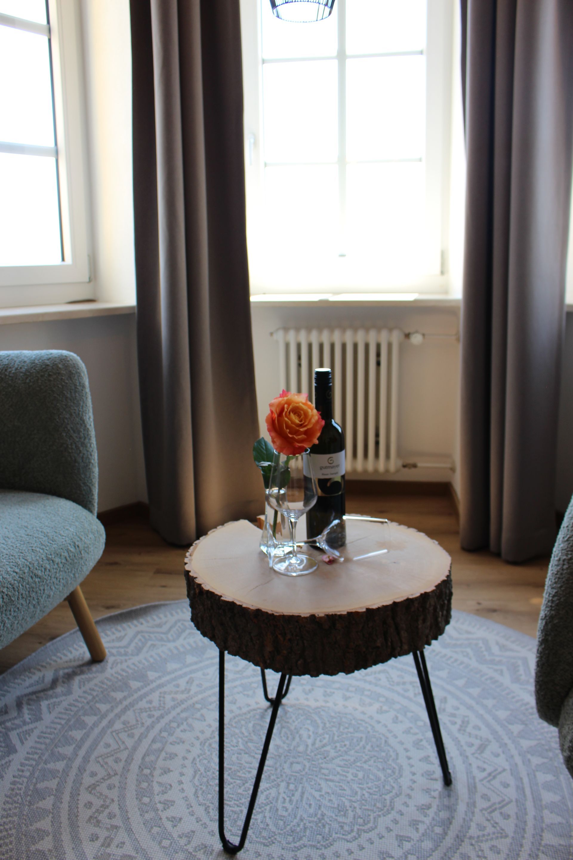 Eine Flasche Wein mit zwei Weingläsern und einer Rose daneben