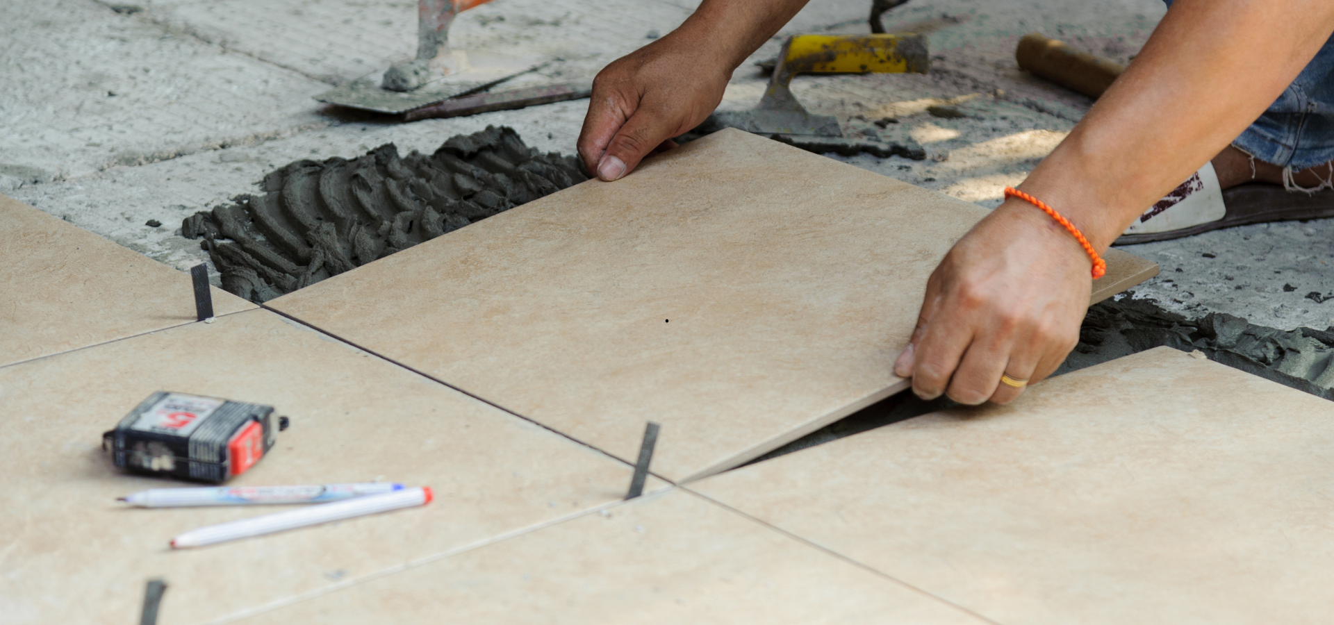 Personne installant des carreaux, utilisant des entretoises.