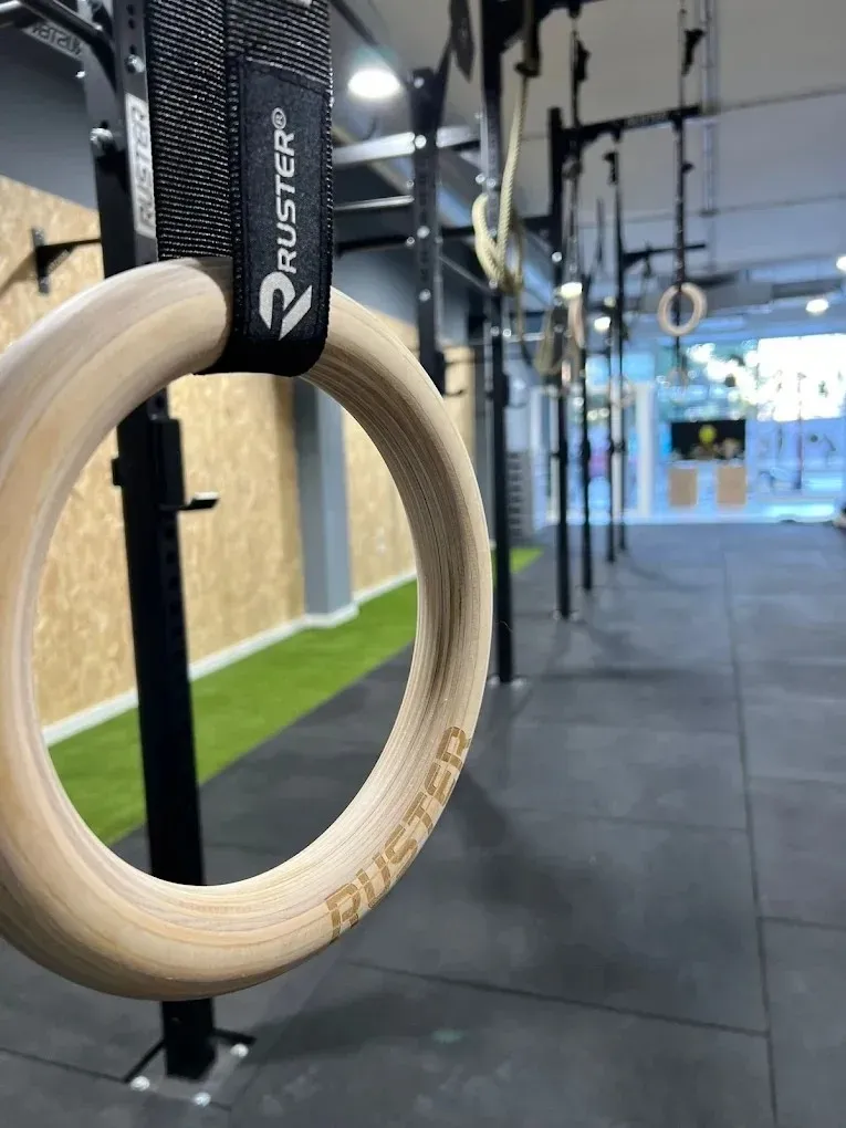 Anillas de gimnasia de madera colgando en un moderno gimnasio de entrenamiento interior.
