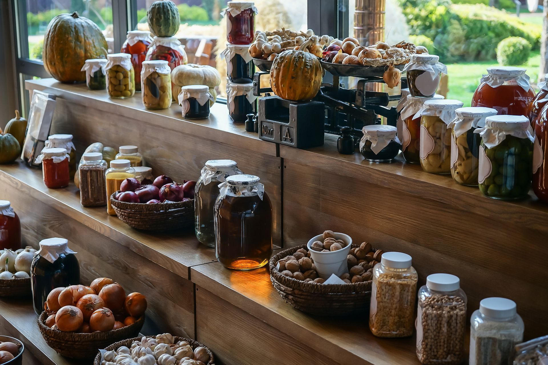 Buffet de madera con tarros de conserva, calabazas y cuencos de comida.