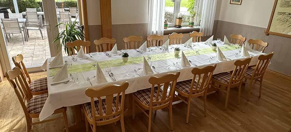 Ein großes Esszimmer voller Tische und Stühle und roter Servietten.