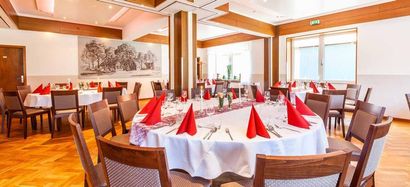 Ein großes Esszimmer mit Tischen und Stühlen, die für eine Party aufgestellt sind.
