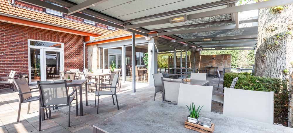 Auf der Terrasse eines Restaurants stehen Tische und Stühle.