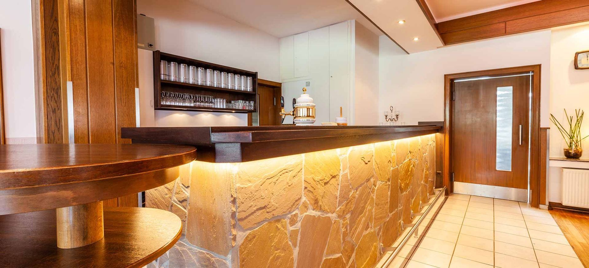 Ein Restaurant mit einer Holztheke und einer Steinwand.