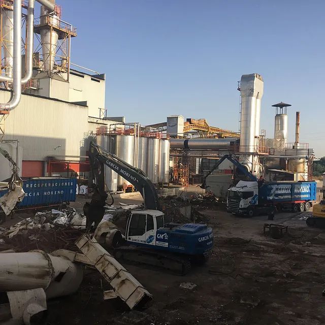 Un sitio de construcción con un camión azul que dice