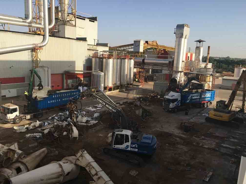 Un edificio grande con mucha maquinaria delante de él.