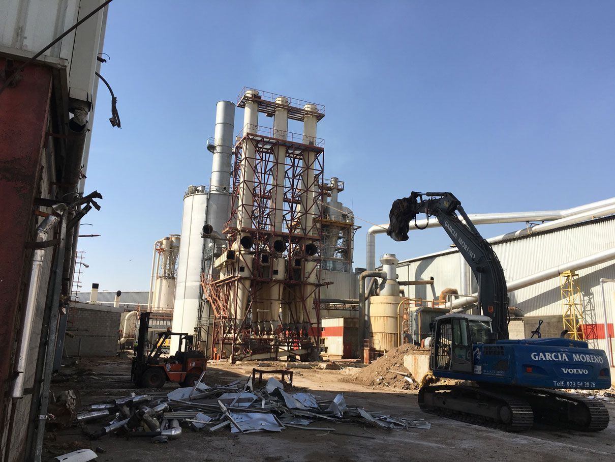 Una gran excavadora azul está situada delante de un gran edificio.