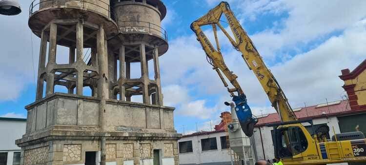 Una grúa amarilla está trabajando en un edificio en una ciudad.