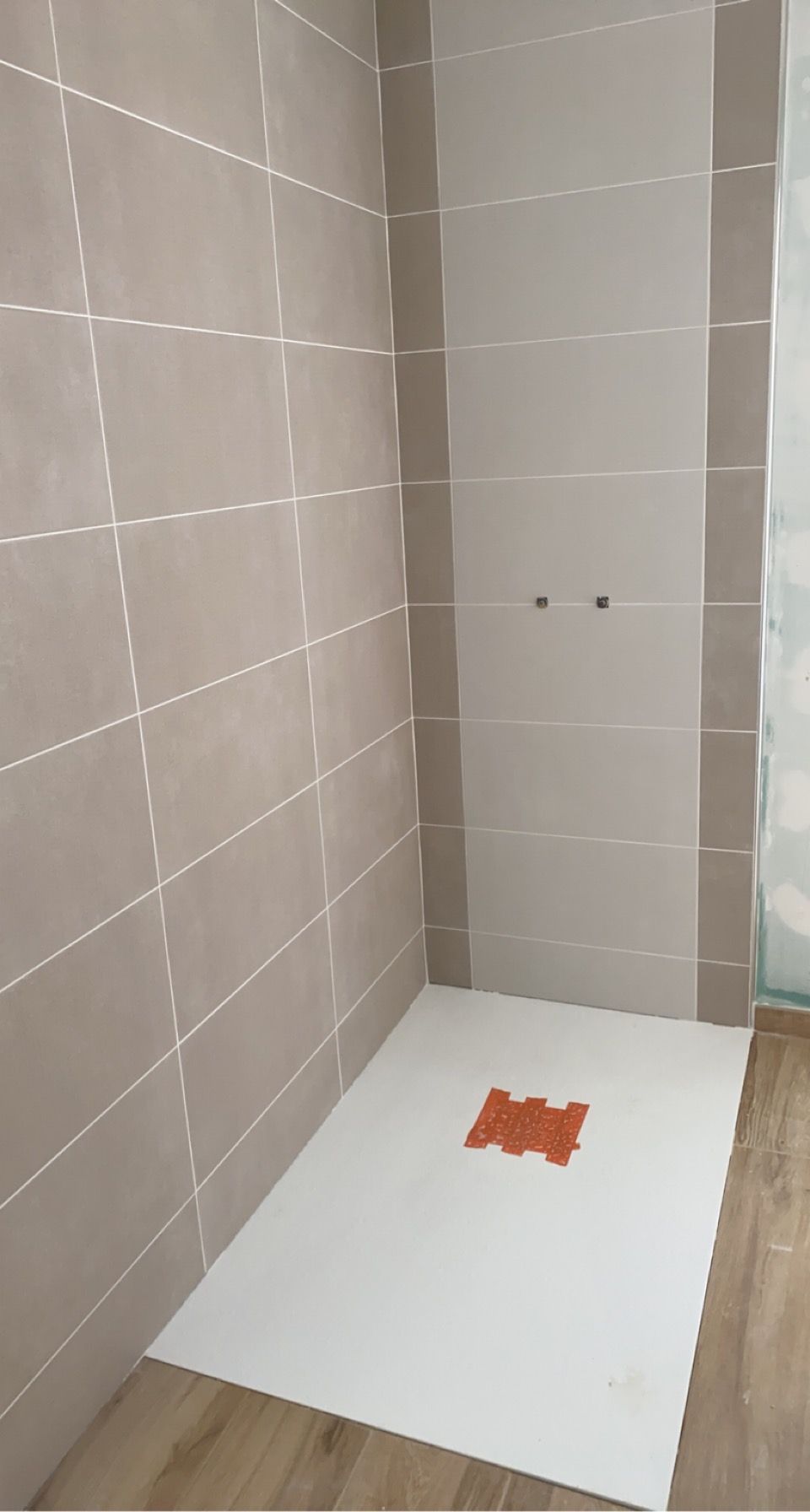 Pose de carrelage rectangulaire marron et blanc dans une salle de bains