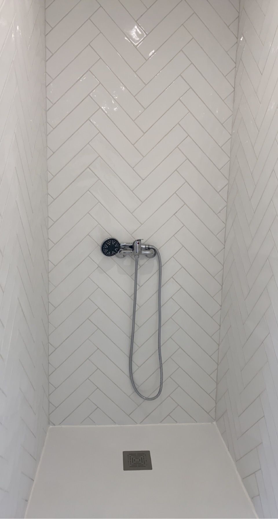 Douche avec pose de carrelage blanc en chevron sur les murs