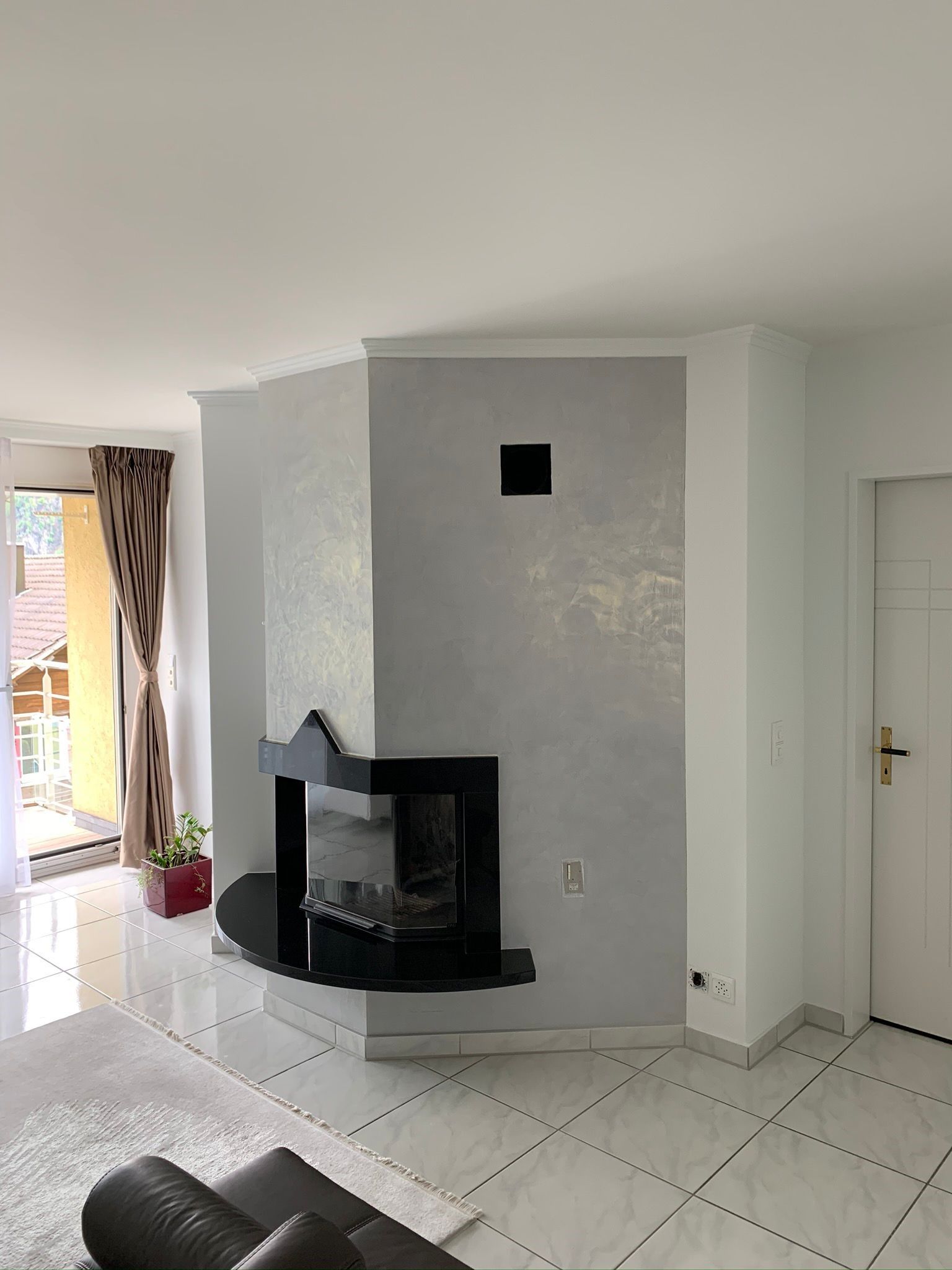 Ein Mann mit Schutzhelm verputzt eine Wand.