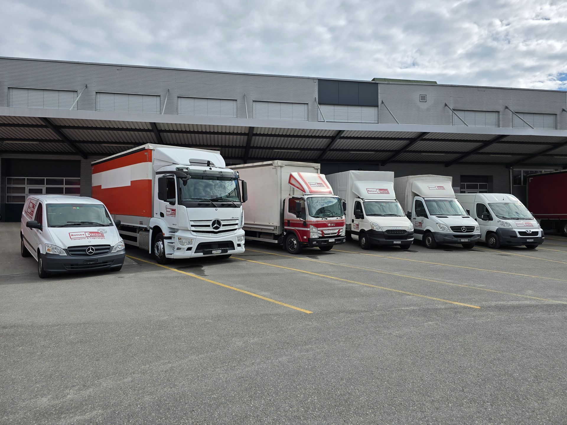 Zwei Männer laden Kisten in einen Lieferwagen.