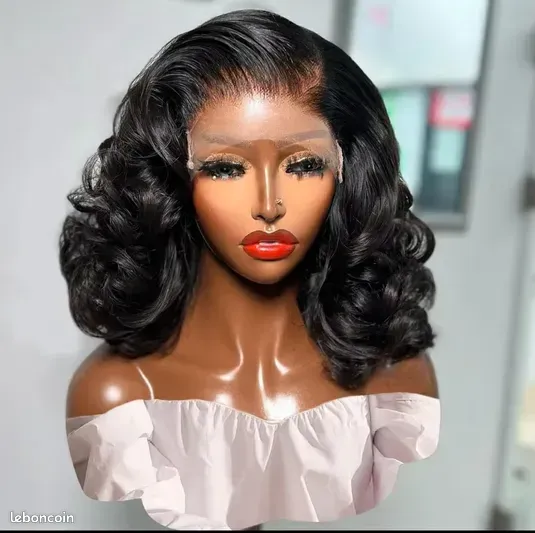 Femme portant une perruque noire bouclée, du rouge à lèvres rouge et un haut blanc à épaules dénudées.