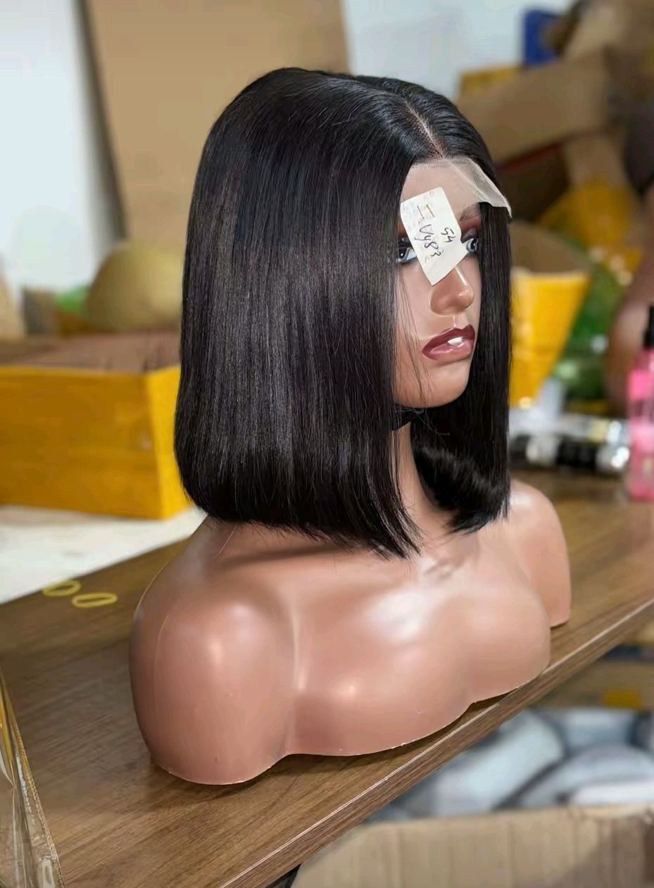 Perruque bob noire sur une tête de mannequin, coupe courte et droite.