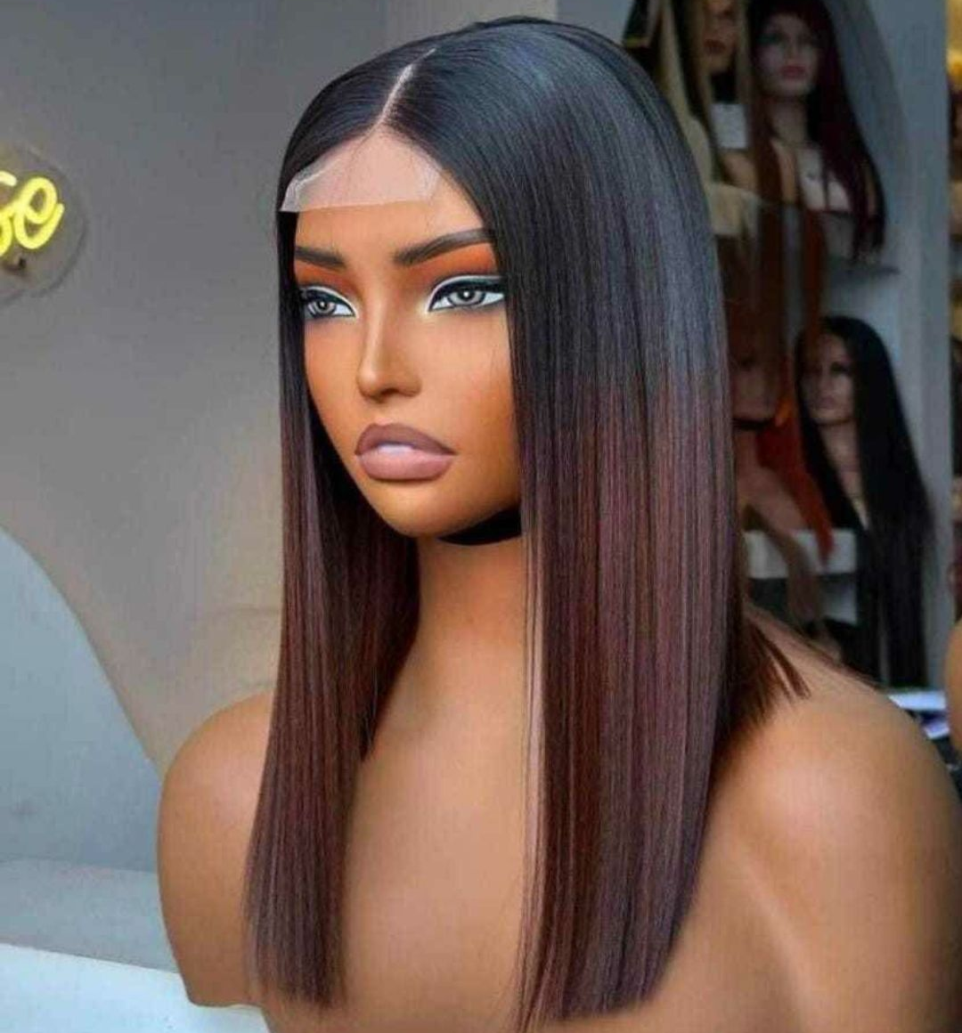 Mannequin portant une longue perruque lisse avec des racines foncées et des pointes auburn, mettant en valeur une coiffure.